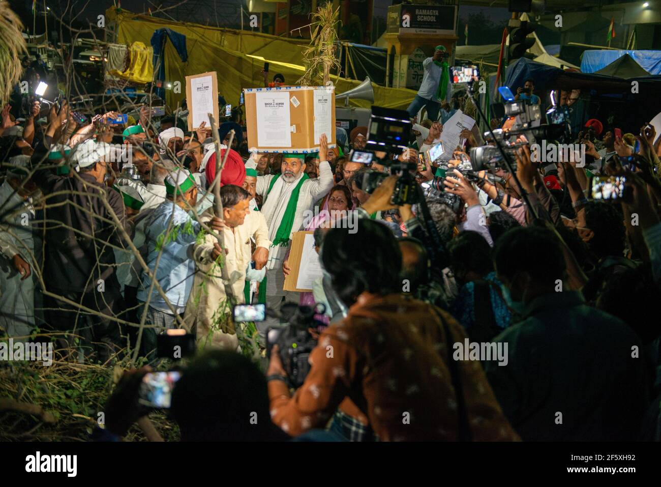 Ghaziabad, Inde. 28 mars 2021. Rakesh Tikait, le dirigeant syndical de Bhartiya kisan, et les agriculteurs transportant des copies des nouvelles lois agricoles qui seront brûlées à la veille du festival Holi pendant les manifestations en cours à la frontière de Ghazpur contre le nouveau projet de loi agricole. (Photo de Pradeep Gaur/SOPA Images/Sipa USA) crédit: SIPA USA/Alay Live News Banque D'Images