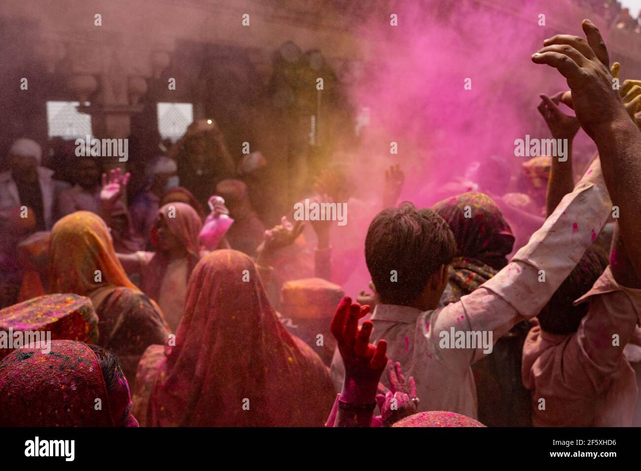 Les gens appréciant l'Holi de Nandgaon. Projection de couleurs dans l'air Banque D'Images