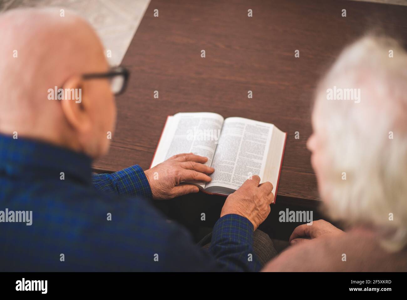 Couple de personnes âgées lisant la bible et priez ensemble à la maison. Banque D'Images