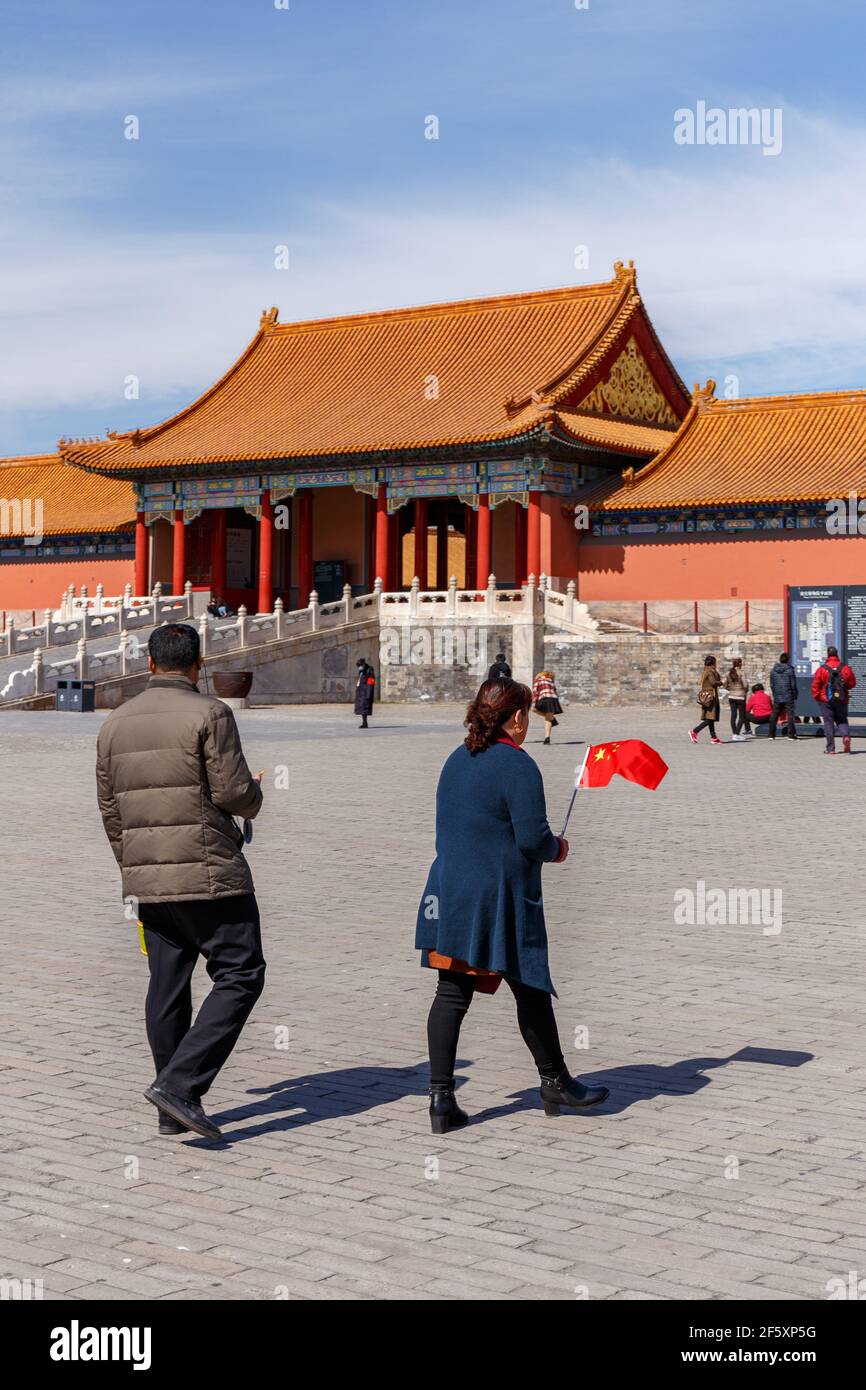 Couple avec un petit drapeau chinois à la Cité interdite à Beijing, Chine en mars 2018. Banque D'Images