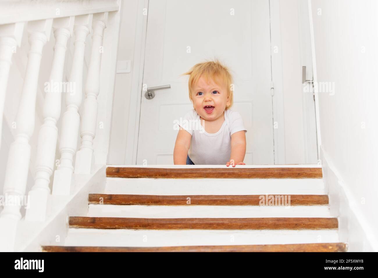 Un petit garçon regarde un peu peur de l'escalier Banque D'Images