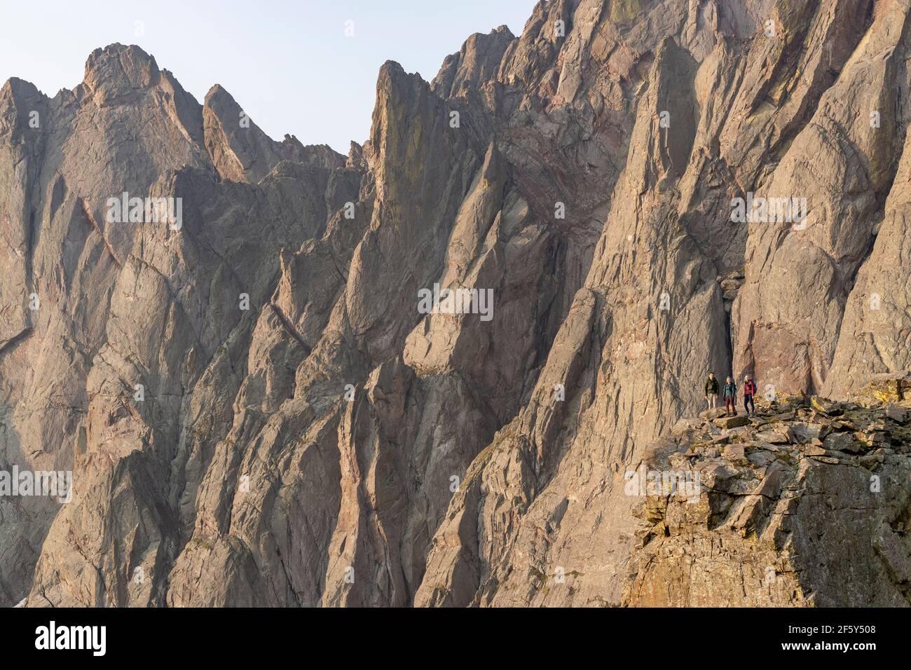 Des routards hommes et femmes se tenant sur des rochers contre la falaise pendant randonnée en vacances Banque D'Images