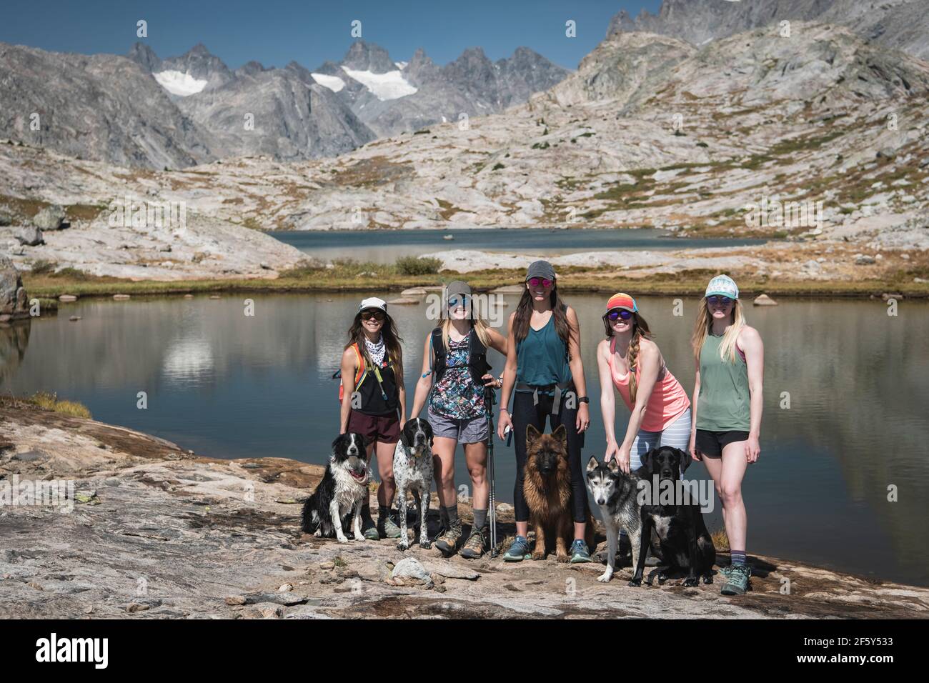Des amies souriantes avec des chiens debout à Titcomb Basin on jour ensoleillé Banque D'Images Des amies souriantes avec des chiens debout à Titcomb Basin on jour ensoleillé Banque D'Images