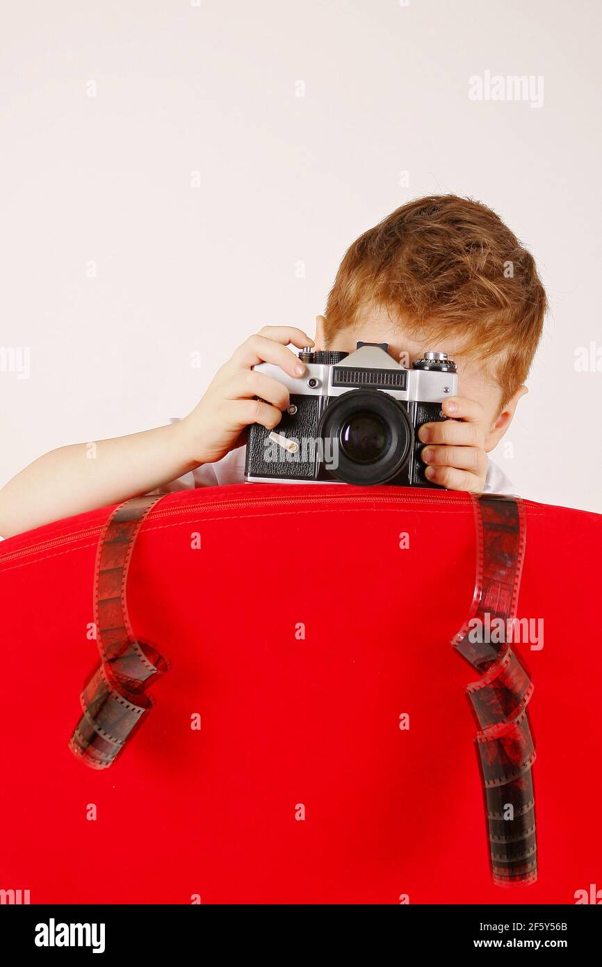 Petit garçon de tirer avec le film photocamera et de rouler en studio, passe-temps d'enfant Banque D'Images