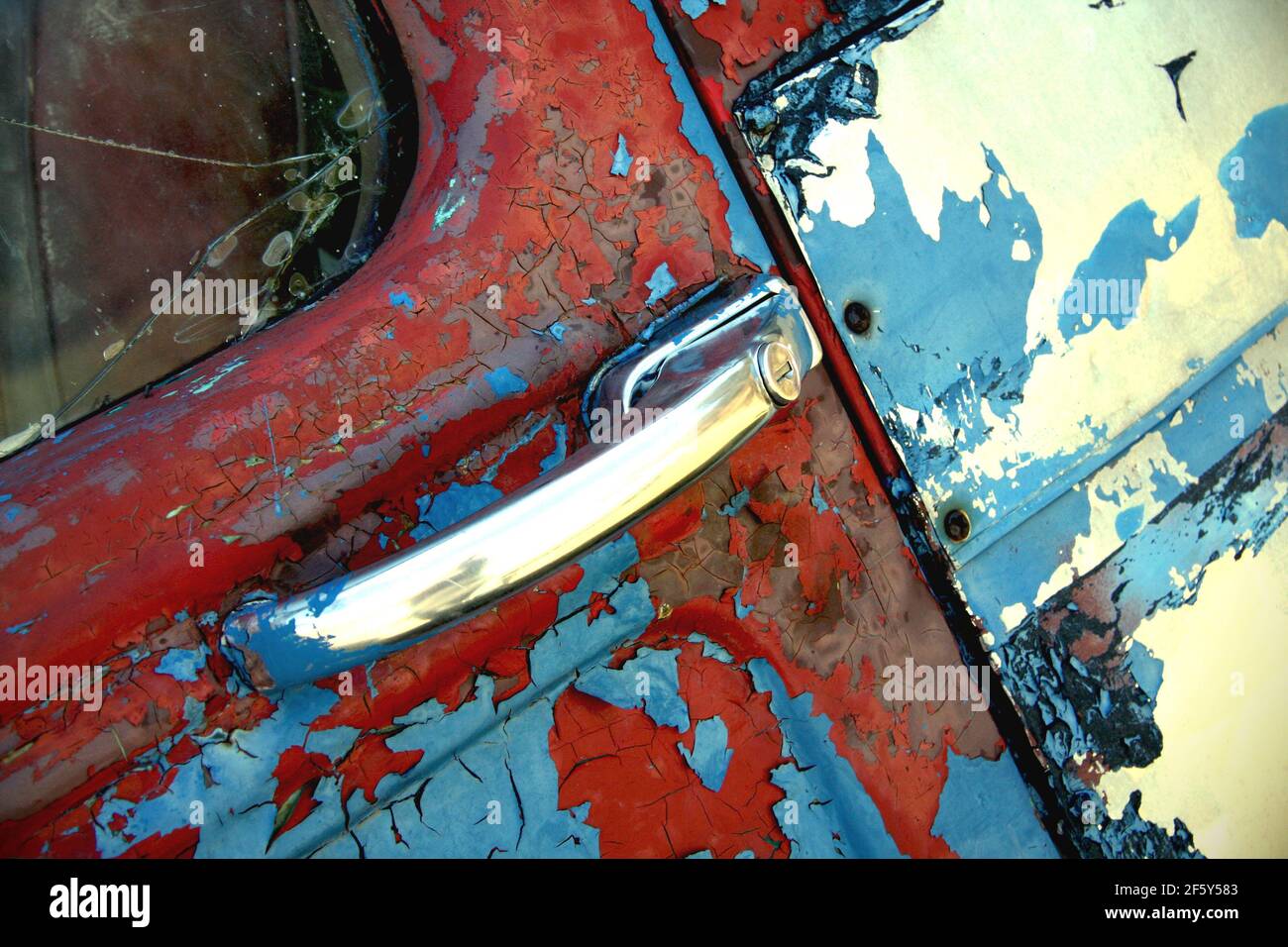 Vieux rouillé notre porte de camion de lait en rouge blanc et bleu avec beaucoup de texture et peinture écaillée Banque D'Images