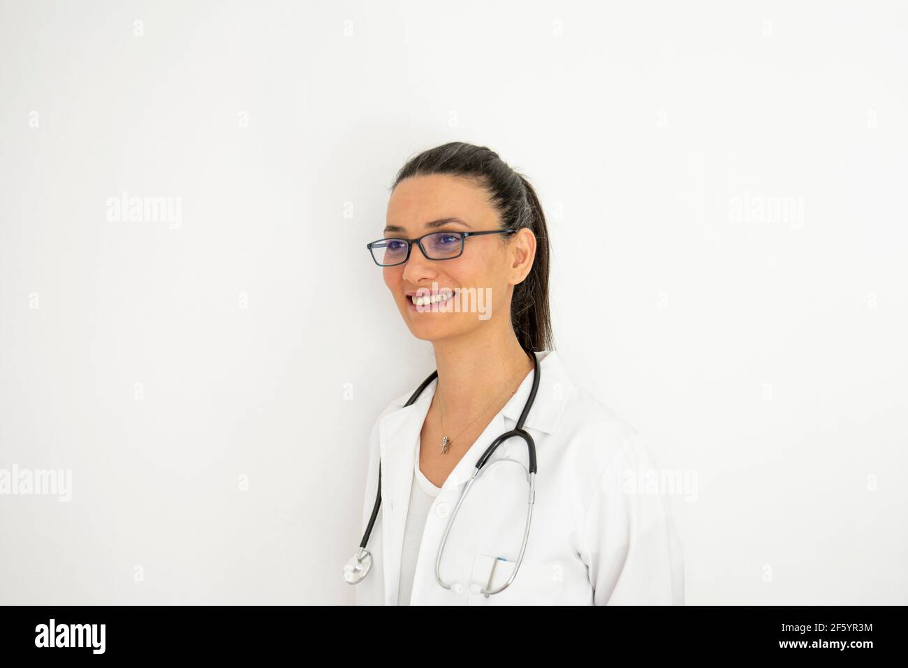 Portrait d'un médecin dans un angle différent et lumières devant un mur blanc. Face de mise au point sélective. Banque D'Images