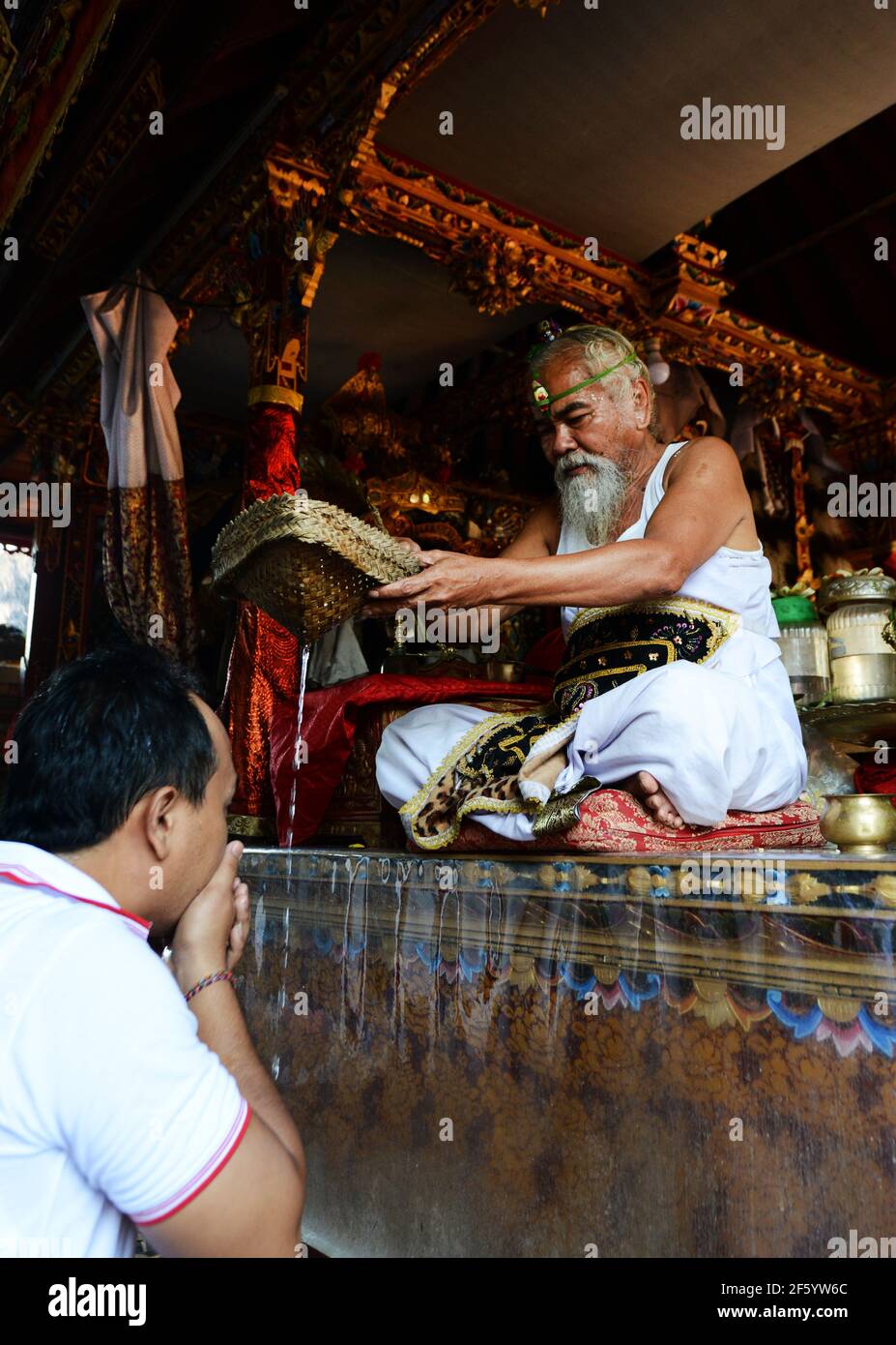 Un prêtre hindou balinais bénit un marié lors d'une cérémonie de pré-mariage dans un petit temple à Ubud, Bali, Indonésie. Banque D'Images