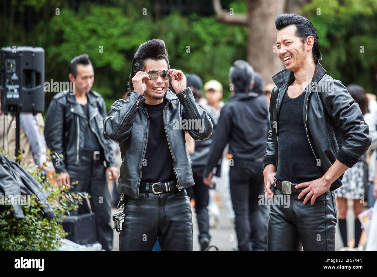 Deux Rockabillies en cuir pantalon avec quiffs partagent une blague à Yoyogi Park, Harajuku, Tokyo, Japon Banque D'Images