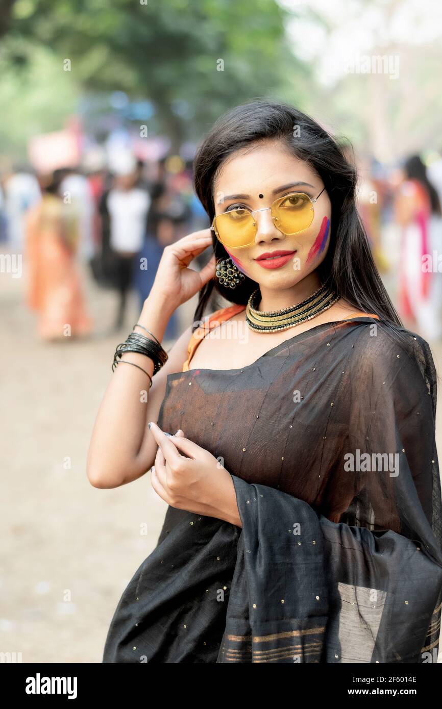 Portrait d'une jeune femme indienne heureuse avec fête de printemps Maquillage célébrant Holi avec des couleurs poudre à Kolkata on Mars 2021 Banque D'Images