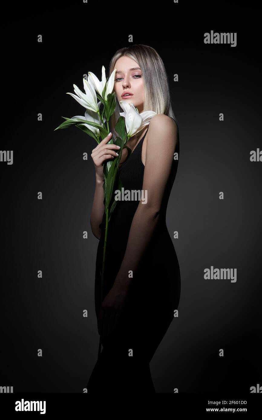 Femme couleur de cheveux d'une blonde avec fleur de nénuphars sur fond noir. Modèle de femme à colorier en couleur de frêne. Portrait d'une fille Banque D'Images