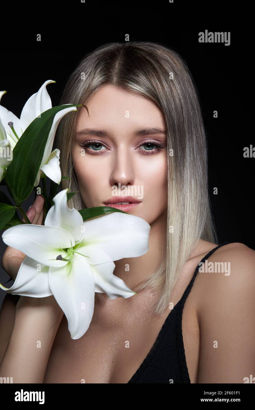 Femme couleur de cheveux d'une blonde avec fleur de nénuphars sur fond noir. Modèle de femme à colorier en couleur de frêne. Portrait d'une fille Banque D'Images