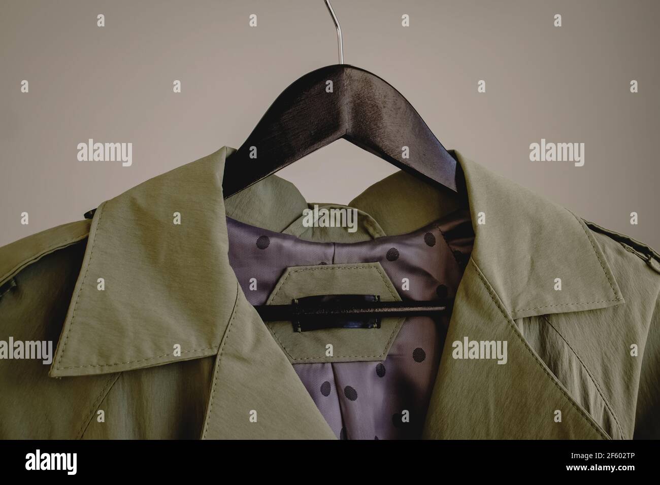 Trench-coat sur cintre en bois noir Banque D'Images