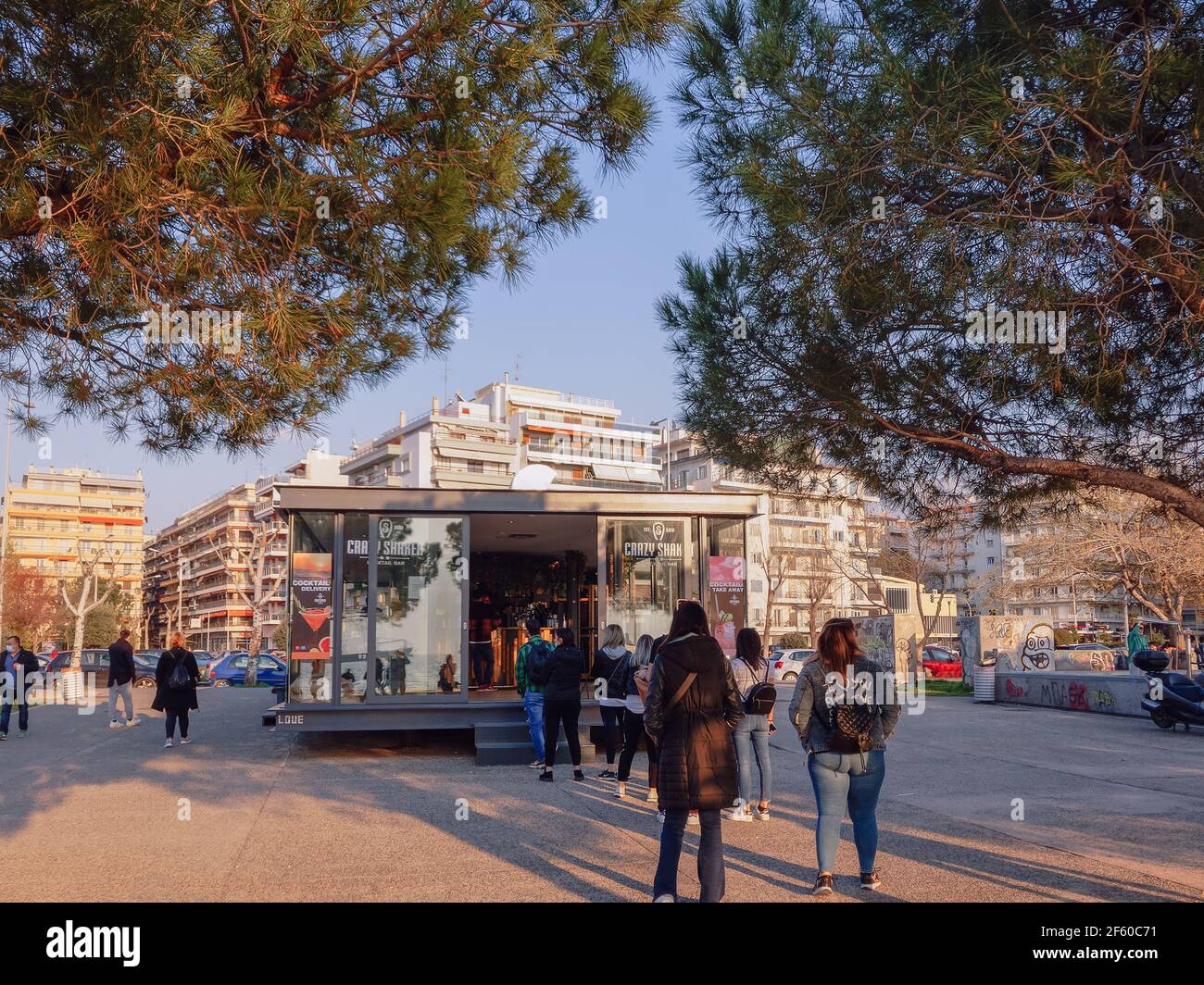 Thessalonique, Grèce - Mars 28 2021 : clients à l'extérieur du bar à emporter en raison de restrictions Covid-19. Une foule hellénique attend en file d'attente pour acheter son cocktail dans un magasin au bord de l'eau. Banque D'Images