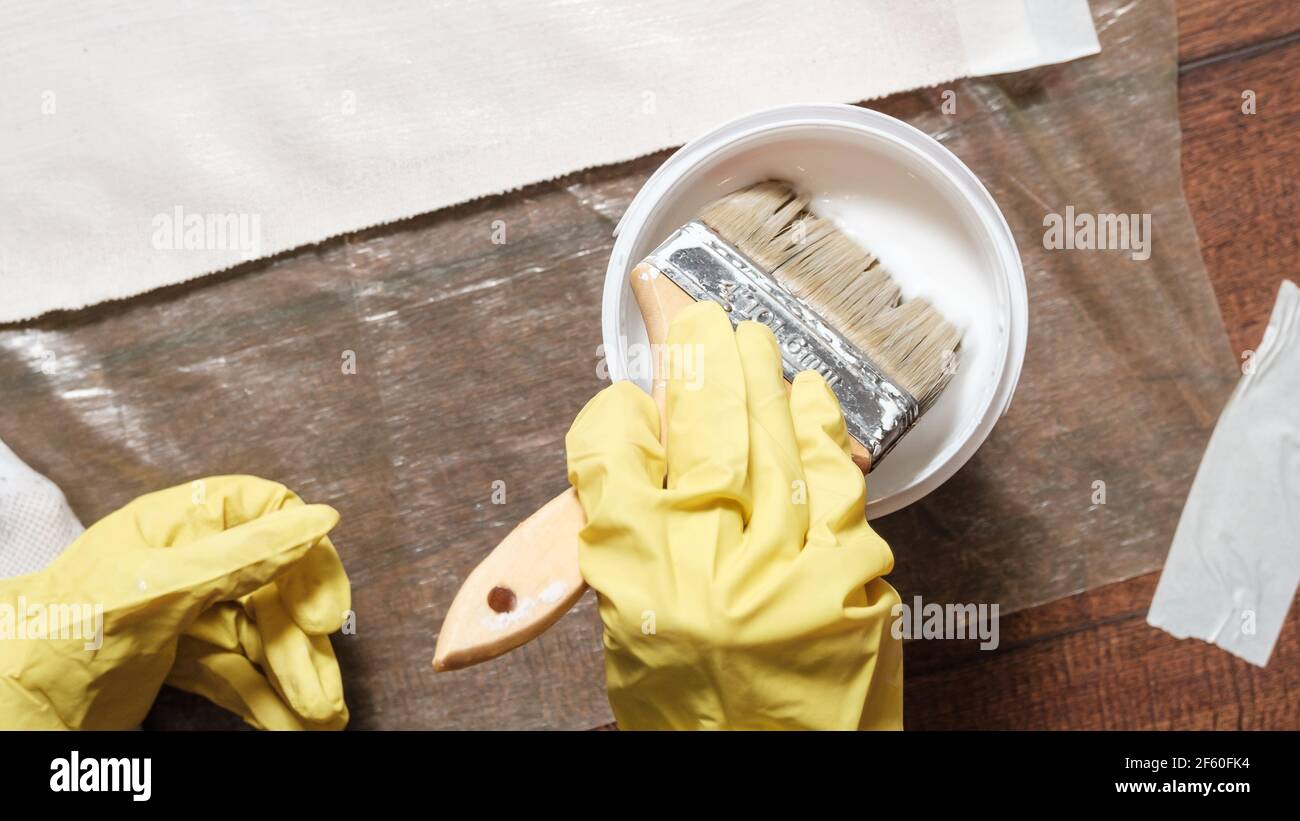 Appliquer de la colle blanche sur le tissu de coton à l'aide d'une brosse Banque D'Images