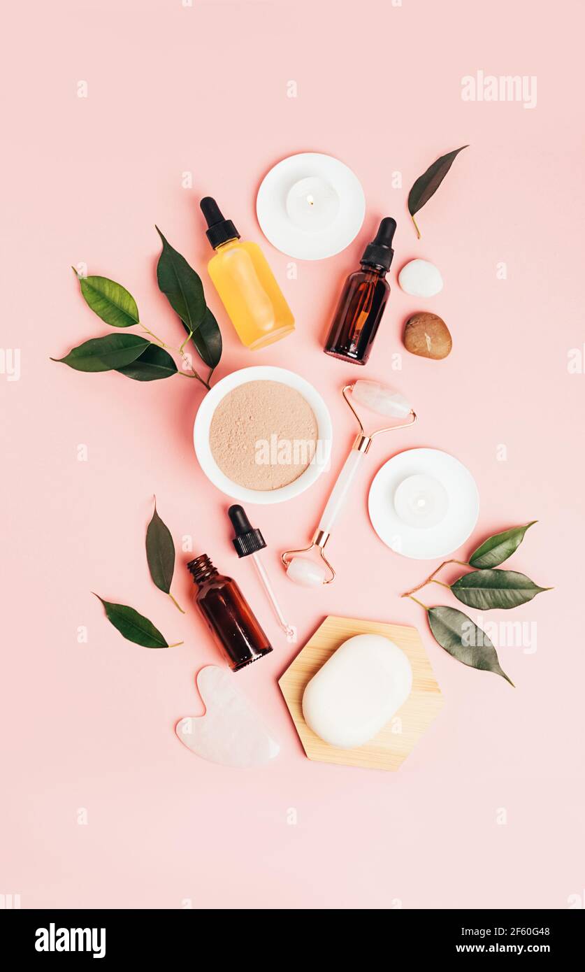 Composition spa sur fond rose pastel. Cosmétiques naturels bio bouteille d'huile, crème, argile, sel, outil de massage gua sha accessoires plan Banque D'Images