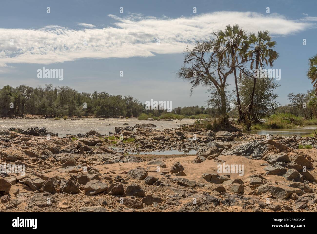 Vue sur le paysage de la rivière Kunene, la rivière frontalière entre la Namibie et l'Angola Banque D'Images