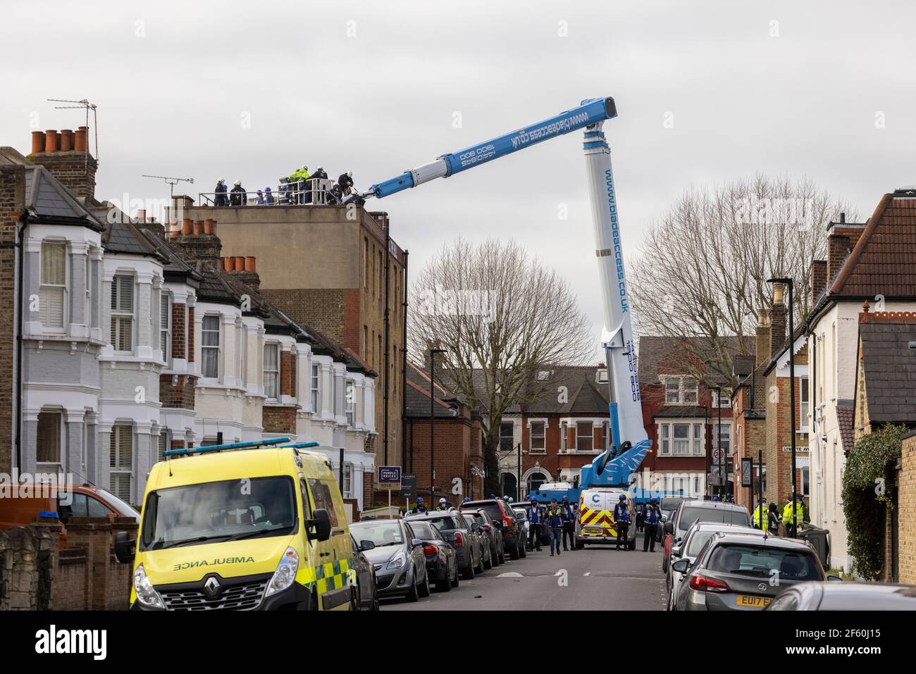 Londres, Royaume-Uni. 29 mars 2021. Une grue est utilisée pour accéder aux manifestants sur le toit. Le poste de police était occupé par des squatters et des militants autonomes sous le nom de «pas UN magasin de la CdP» depuis plus d'une semaine, en opposition au nouveau «projet de loi sur la police, la criminalité, la condamnation et les tribunaux» et au nouveau «projet de loi sur le féminicide. Cavendish Road police Station, Clapham, Londres, Royaume-Uni. Crédit : Joshua Windsor/Alay Live News. Banque D'Images