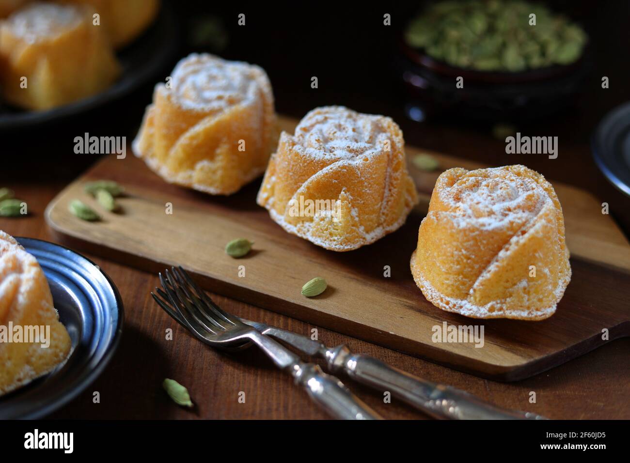 Petits gâteaux de Savoie faits maison fraîchement cuits à la cardamome en forme de rose avec dosettes de cardamome Banque D'Images