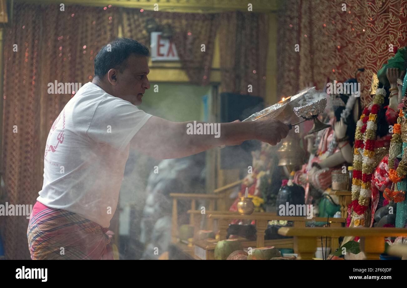 Un adorateur hindou dévot fait des flammes devant des déités dans un temple de Queens, New York City.profile, 2018 Banque D'Images