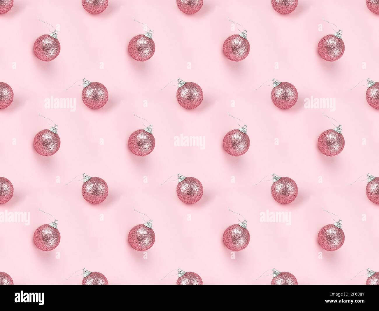 Motif de Noël sans couture isométrique sur fond rose avec boules festives. Concept nouvel an des fêtes. Concept minimal de pose à plat Banque D'Images