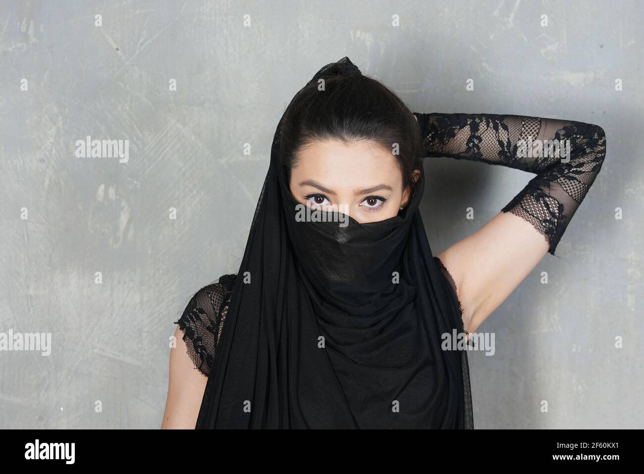 Portrait de femme contre le mur avec la face inférieure du visage recouvert de tissu Banque D'Images