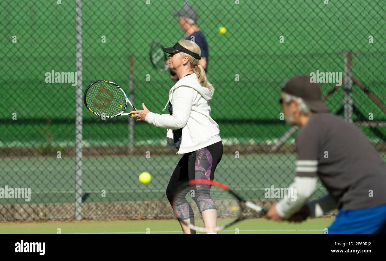 Bournemouth, Royaume-Uni. 29 mars 2021. Les personnes qui pratiquent une partie de tennis au soleil au Bournemouth Gardens tennis Centre le premier jour des sports de plein air étant admis dans le cadre de l'assouplissement des restrictions suite au troisième confinement national de la pandémie Covid-19. . Credit: Richard Crease/Alay Live News Banque D'Images