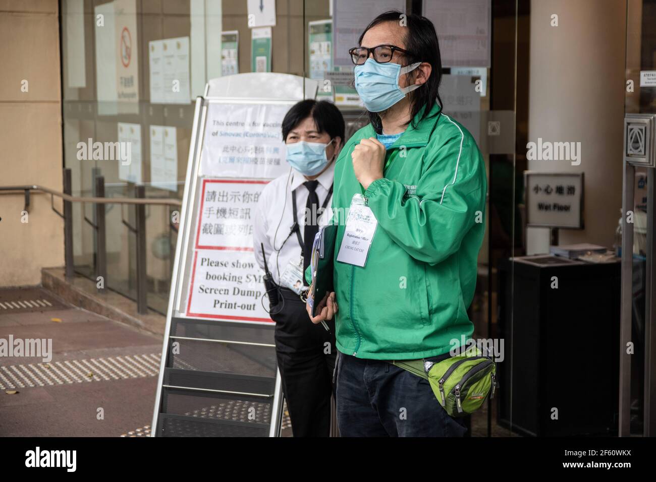 Hong Kong, Chine. 18 mars 2021. Un membre du personnel du Centre communautaire de vaccination s'entretient avec des participants à l'extérieur de la Bibliothèque centrale de Hong Kong. Les citoyens de Hong Kong assistent au Centre communautaire de vaccination situé dans l'une des galeries de la Bibliothèque centrale de Hong Kong, dans le district de Tai Hang, le jeudi 18 mars. Credit: Ivan Abreu/SOPA Images/ZUMA Wire/Alay Live News Banque D'Images