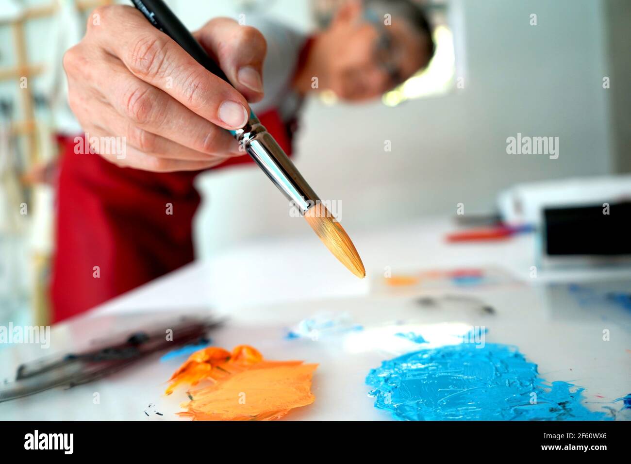 Artiste travaillant dans son studio avec des pinceaux et un imprimé Banque D'Images