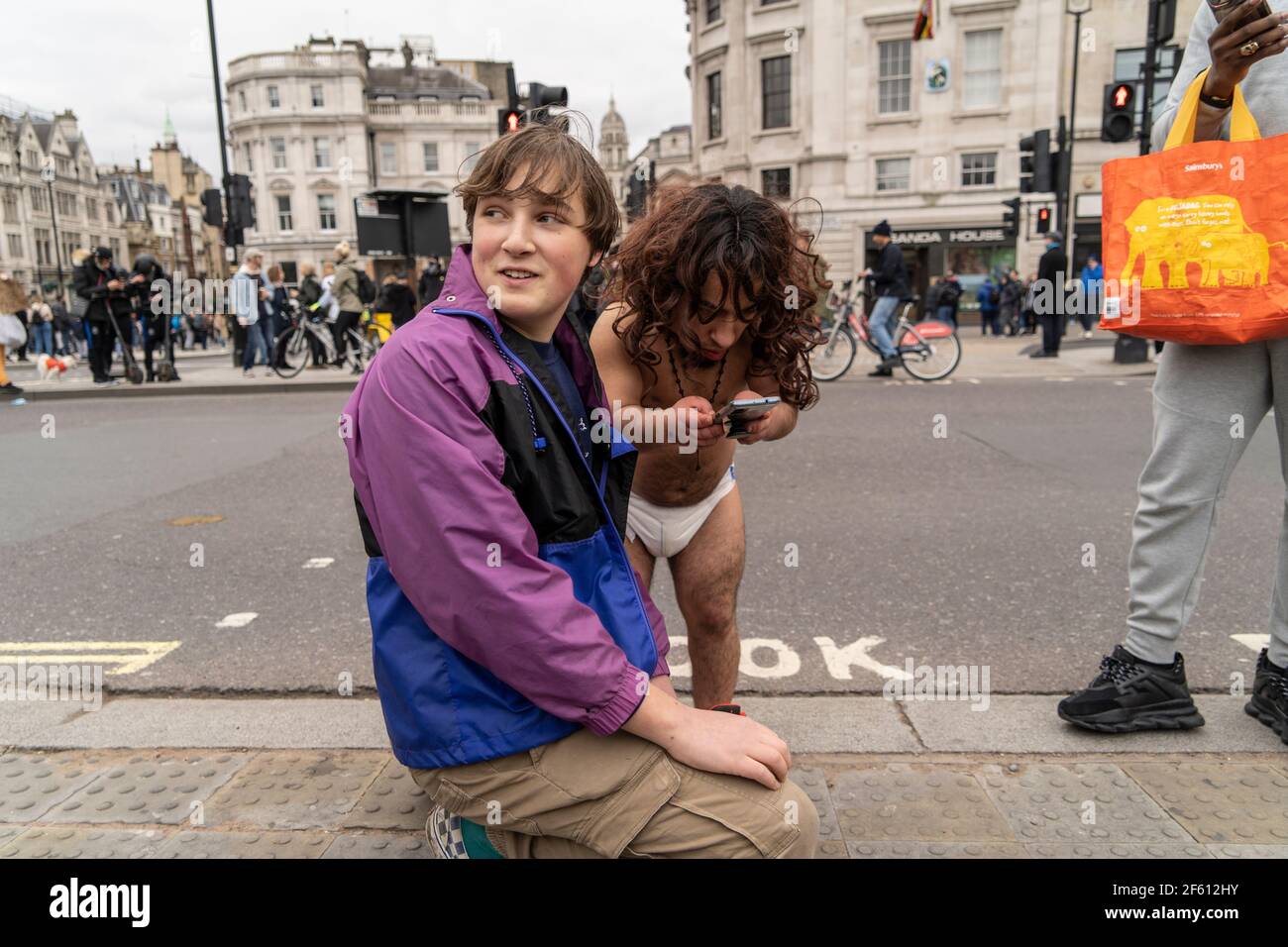 Lors de la manifestation anti Lockdown à Londres, au Royaume-Uni, le jeune homme voit quelque chose en ligne. 20.03.21 Banque D'Images