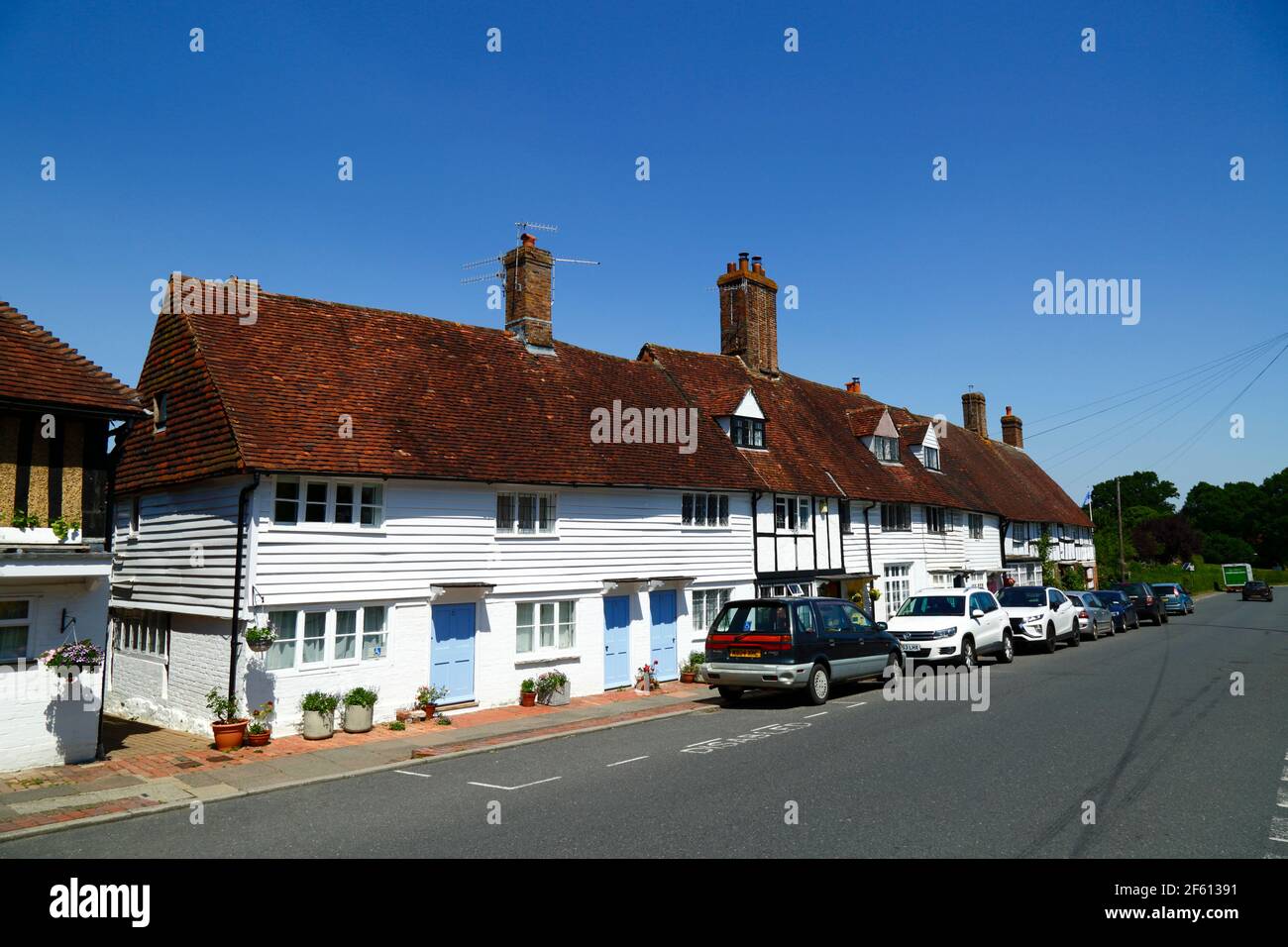 Typique de panneaux d'intempéries peints en blanc et demi-chalets encadrés en bois à côté de la route principale à travers le village, Hartfield, East Sussex, Angleterre Banque D'Images