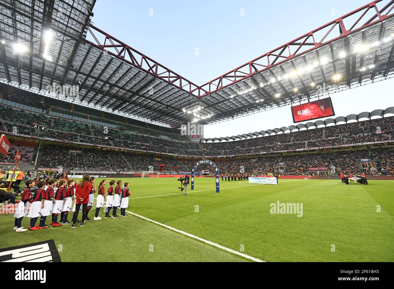 Les enfants portant les uniformes de l'AC Milan entrent sur le terrain du stade de football de