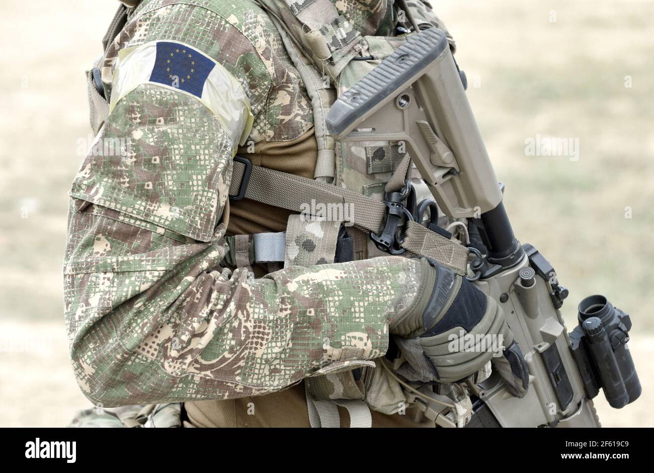 Soldat avec fusil d'assaut et drapeau de l'Europe sur l'uniforme militaire. Collage. Banque D'Images