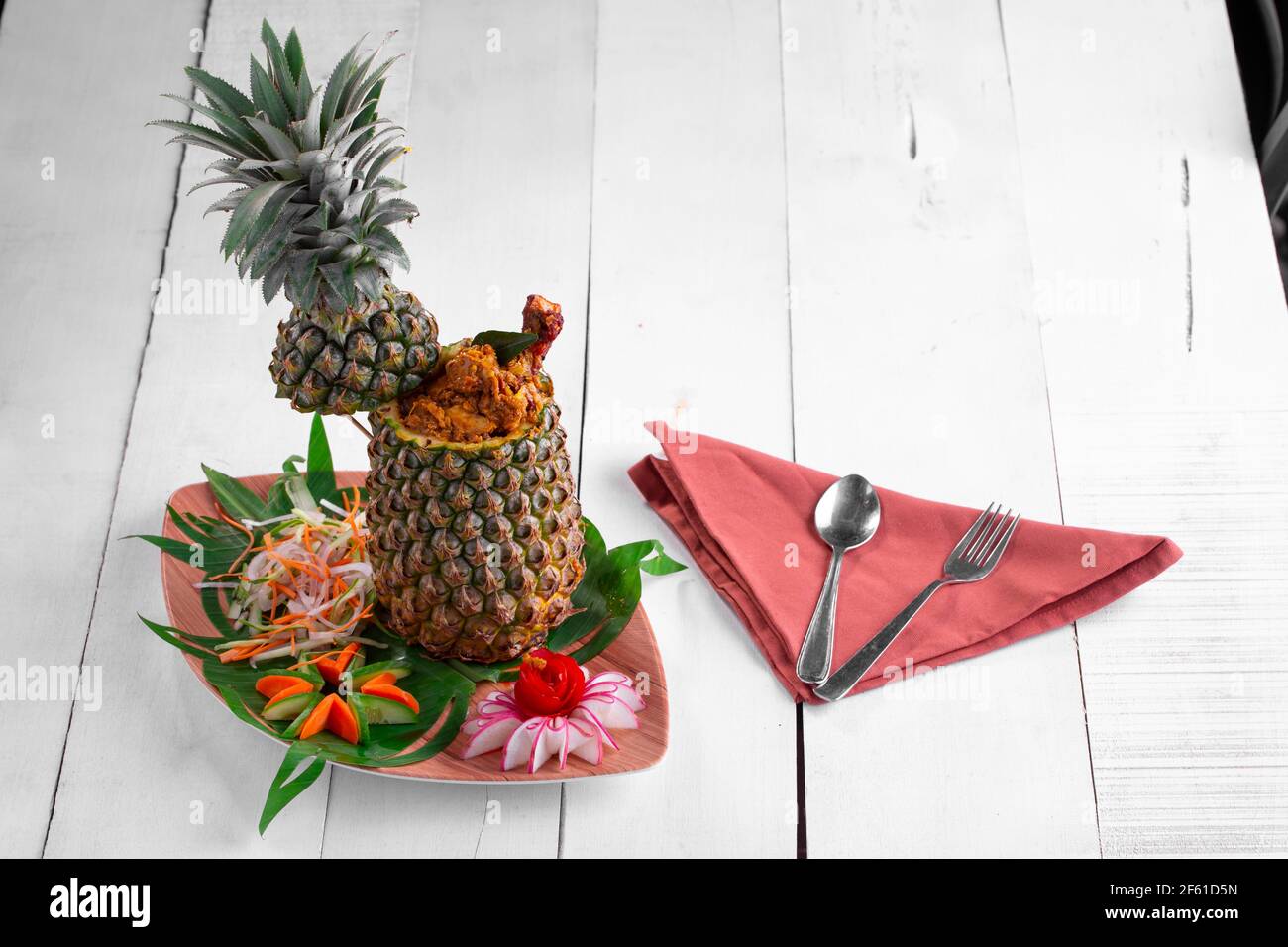 Poulet à l'ananas ou poulet farci à l'ananas joliment agencé dans une table avec fond en bois blanc. Banque D'Images