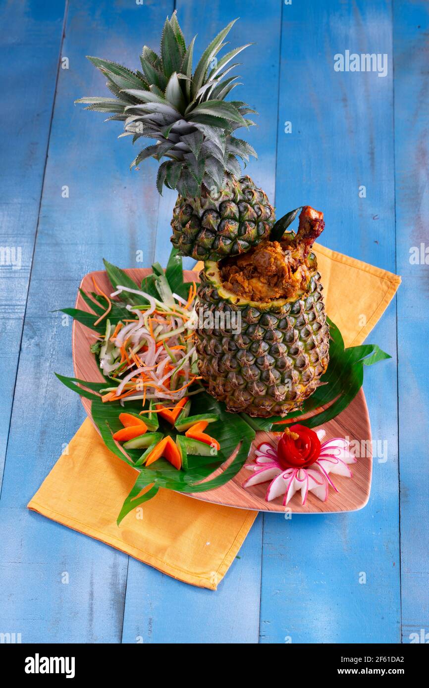 Poulet à l'ananas ou poulet farci à l'ananas joliment agencé dans une table avec fond en bois bleu. Banque D'Images
