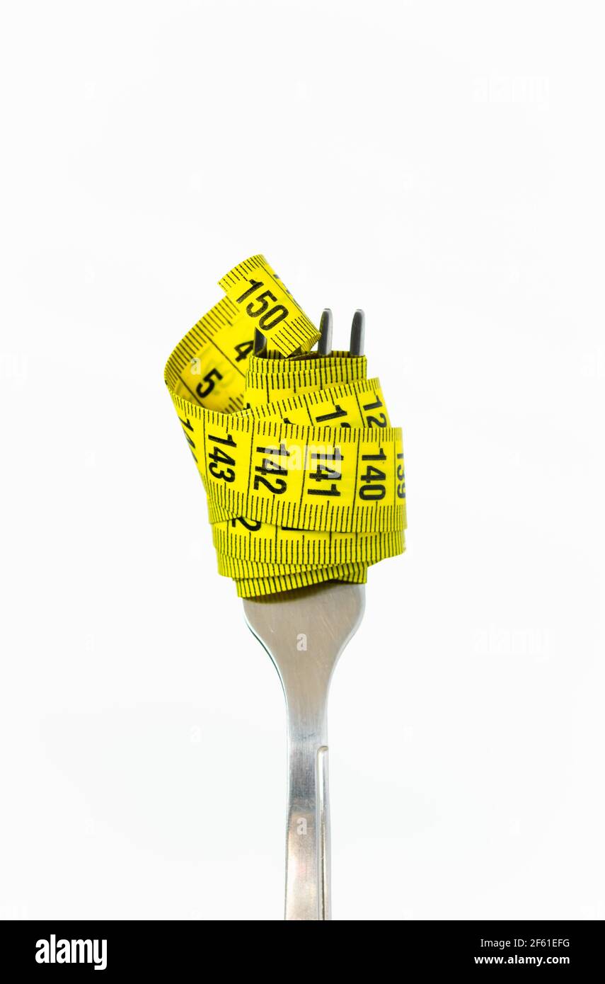 concept de régime, fourchette avec ruban de mesure jaune sur fond blanc Banque D'Images