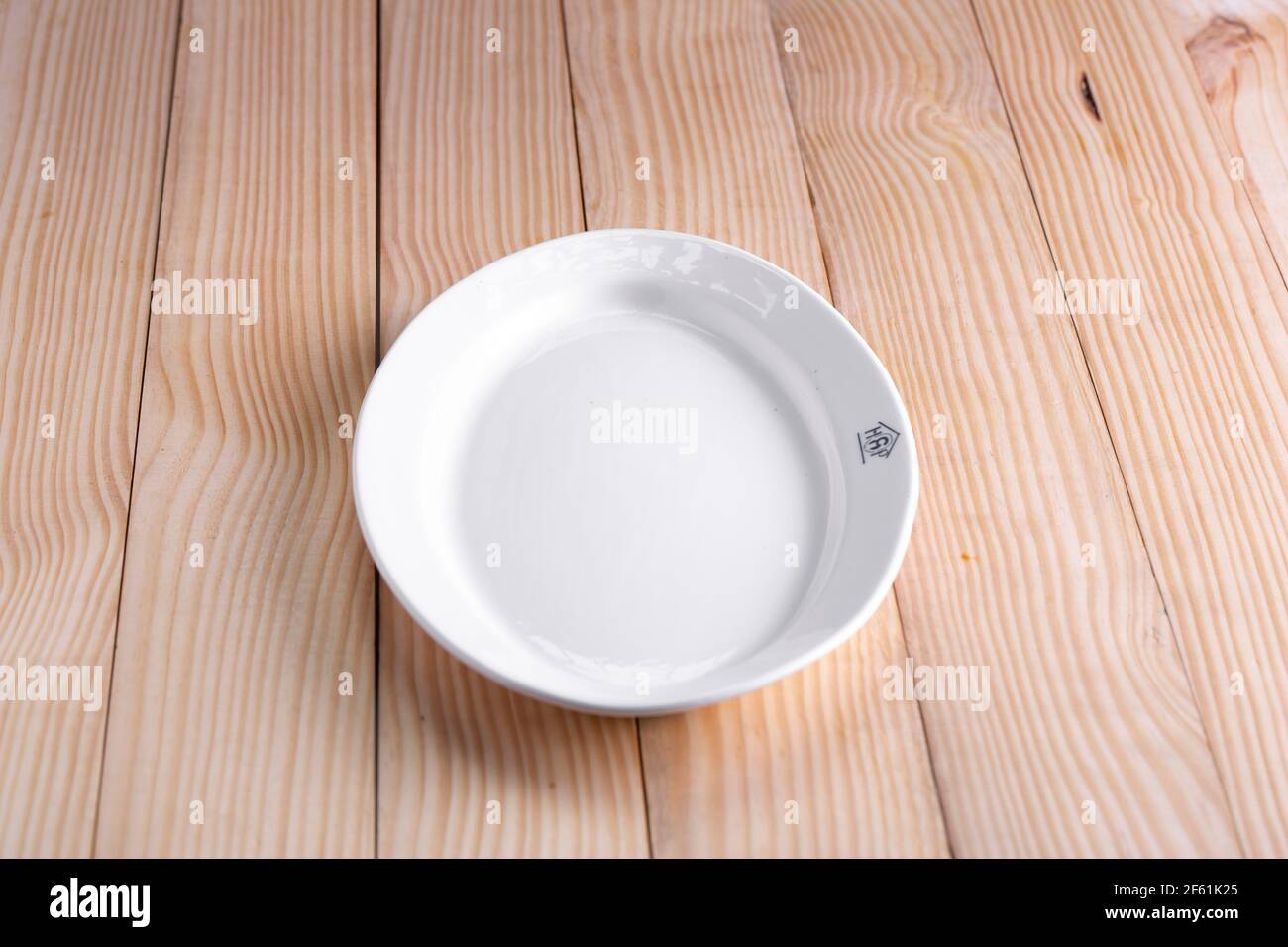 Articles de table blancs, différentes formes d'une vaisselle blanche en céramique vide disposés sur une table en bois, isolé. Banque D'Images