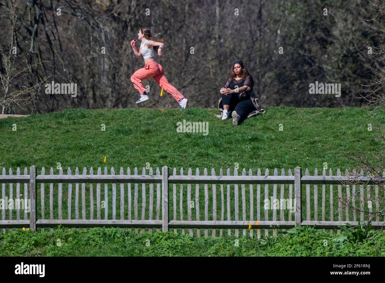 Londres, Royaume-Uni. 29 mars 2021. Les bassins de baignade sont de nouveau ouverts pour la natation en plein air, même si l'eau est encore assez froide, alors certains regardent juste depuis les barrages - le beau temps à Hampstead encourage les gens à se rencontrer à l'extérieur le premier jour de la détente des restrictions de verrouillage, permettre aux gens de se rencontrer en groupes de six personnes, en plein air et de reprendre l'exercice organisé en plein air. Crédit : Guy Bell/Alay Live News Banque D'Images