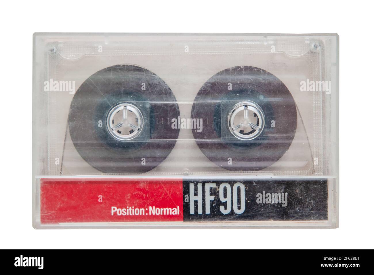 Une cassette audio transparente usée et rayée dans un boîtier de cassette à dosette isolé sur un fond blanc. Gros plan Banque D'Images
