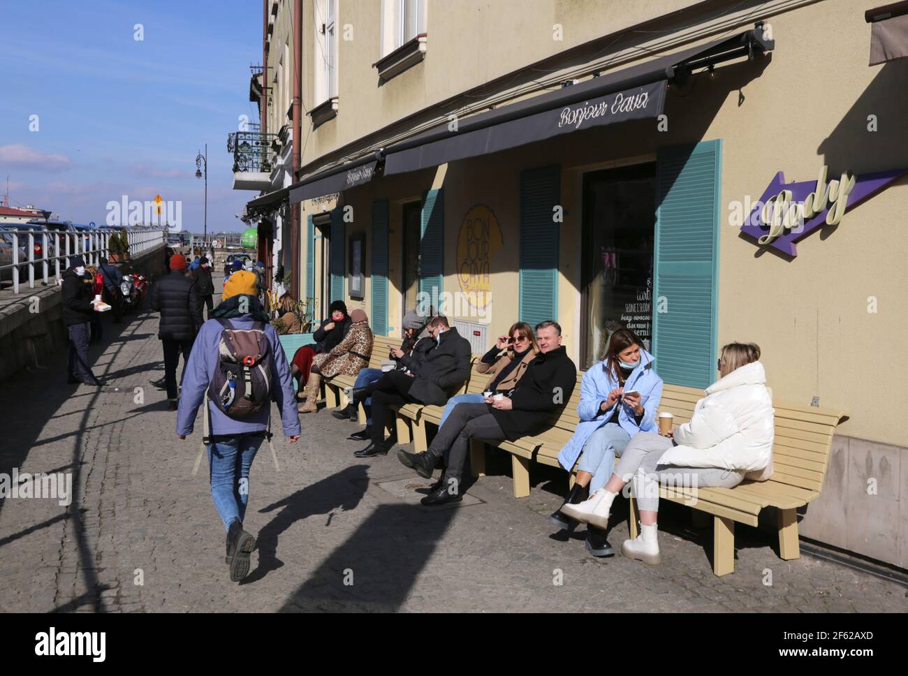 Cracovie. Cracovie. Pologne. Personnes assises sur les bancs devant le café travaillant en mode à emporter uniquement. Nouvelle normale. Banque D'Images