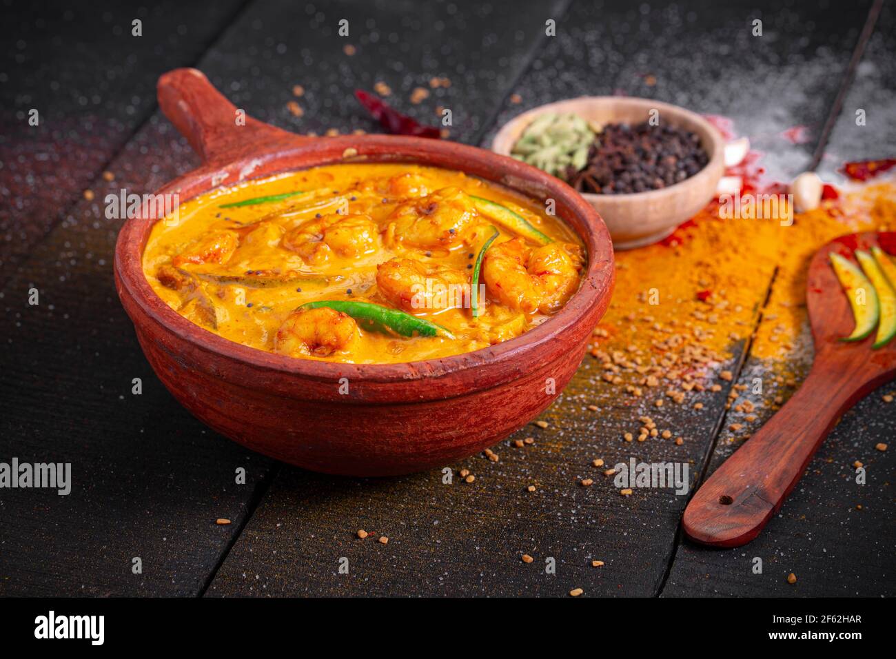 Curry de mangue de crevettes, plat traditionnel de kerala à base de mangue  crue et disposés dans un matériel de contour d'oreille avec un arrière-plan  texturé noir Photo Stock - Alamy