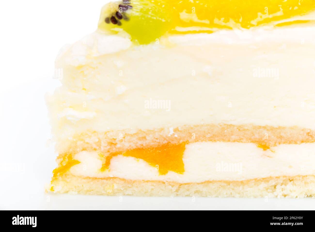 Gâteau crémeux à la mousse de yougurt avec fruits sur le dessus. Macro. La photo peut être utilisée comme arrière-plan entier. Banque D'Images