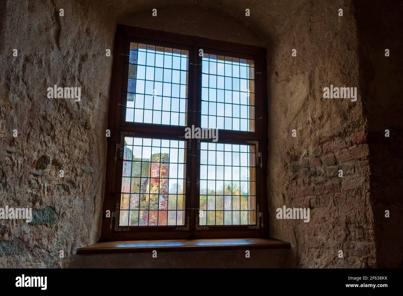 Lumière d'automne traversant une fenêtre en vitraux d'une épaisseur de niche murale dans le château médiéval Banque D'Images