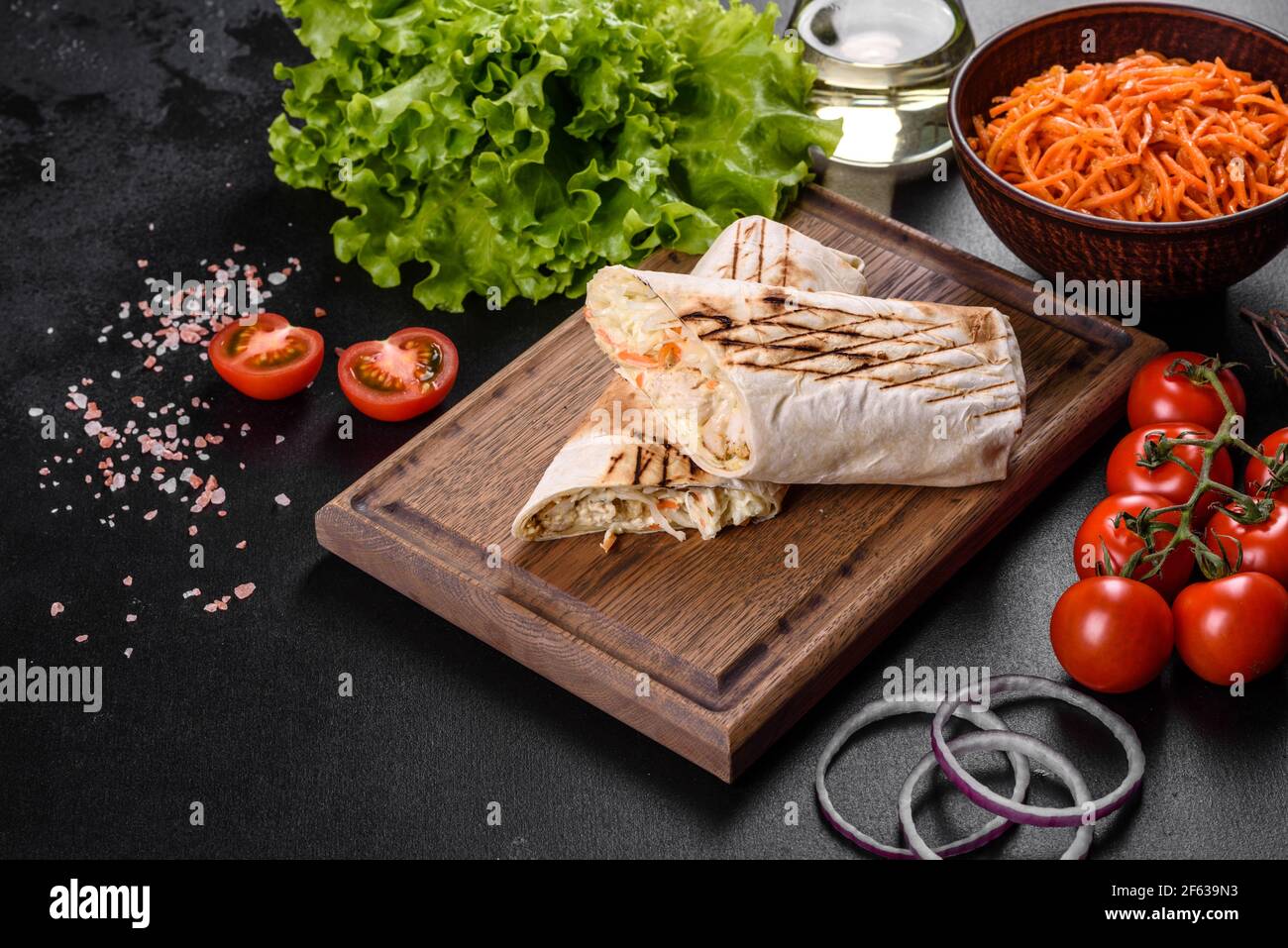 Délicieux shawarma frais avec de la viande et des légumes sur une table en béton sombre. Restauration rapide, cuisine turque Banque D'Images