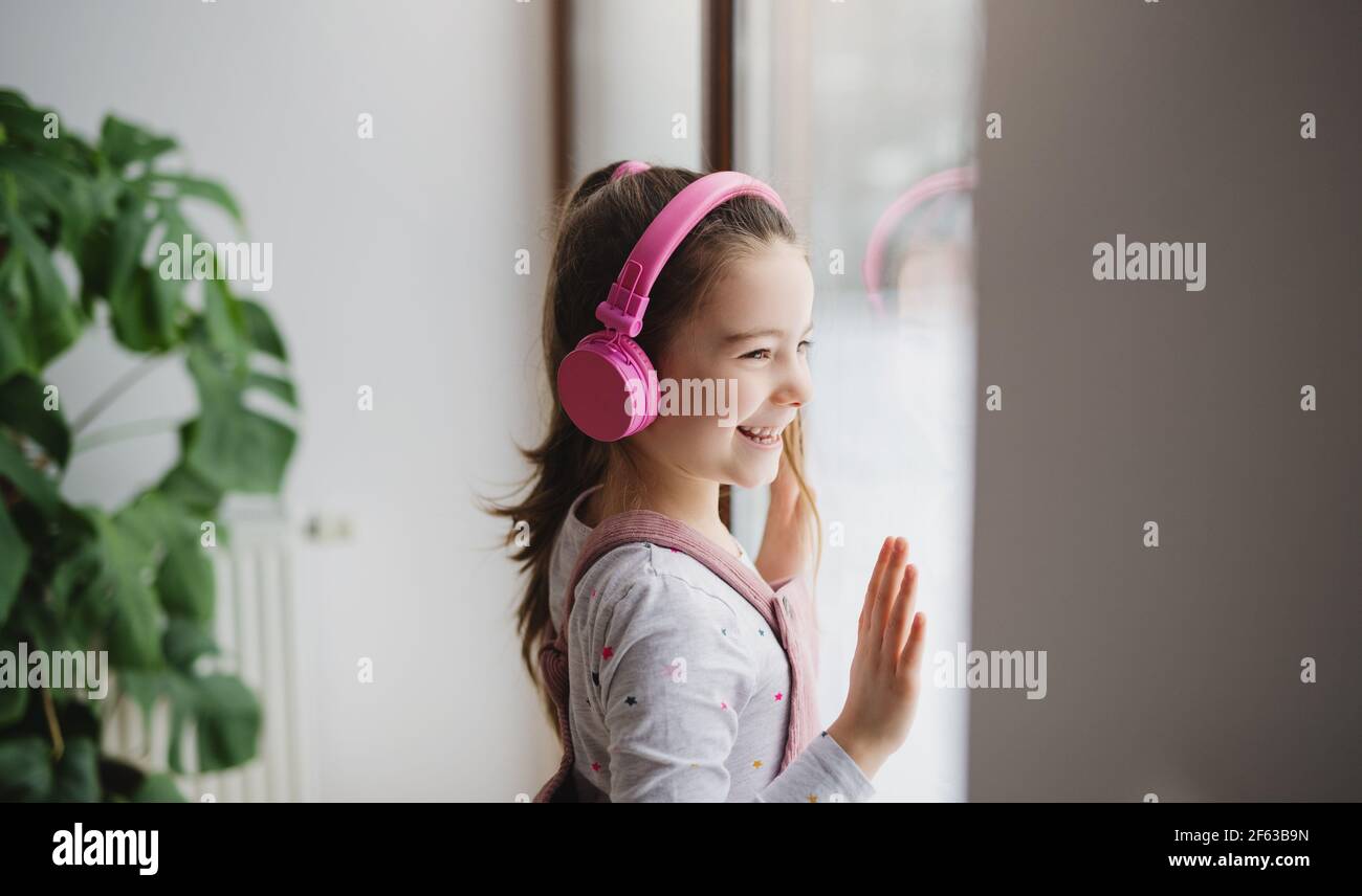 Bonne petite fille avec des écouteurs à l'intérieur à la maison, en écoutant de la musique. Banque D'Images