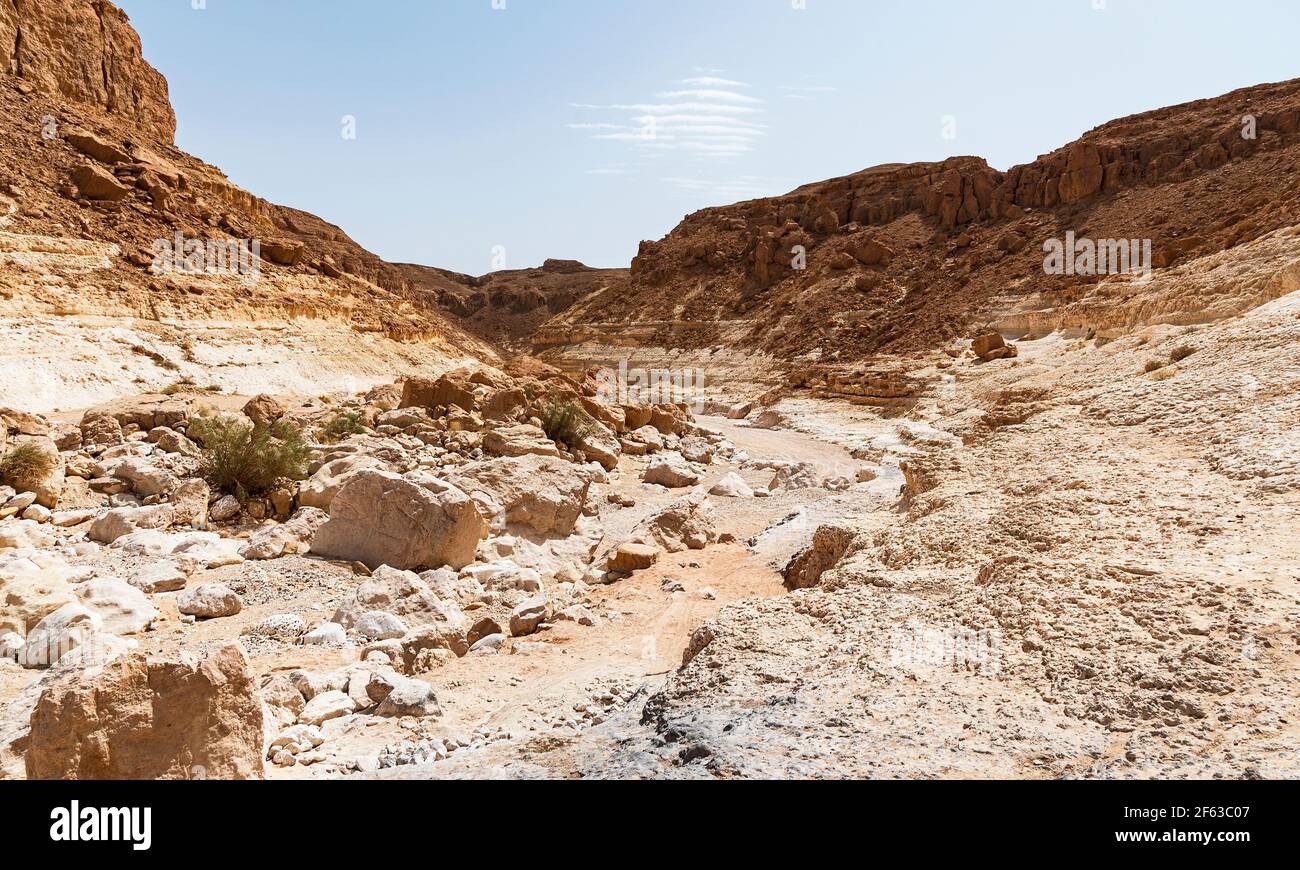 Le ruisseau Nahal Nekarot sort de la rive sud du Cratère de Makhtesh Ramon en Israël à travers le Nekarot Gap avec un ciel bleu pâle en arrière-plan Banque D'Images