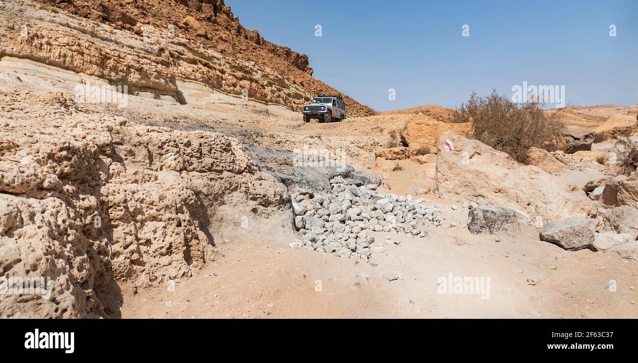 le véhicule tout-terrain s'arrête avant de descendre dans la pente abrupte Dans le lit Nahal Nekarot de ruisseau comme il sort de la Cratère de Makhtesh Ramon en Israël Banque D'Images