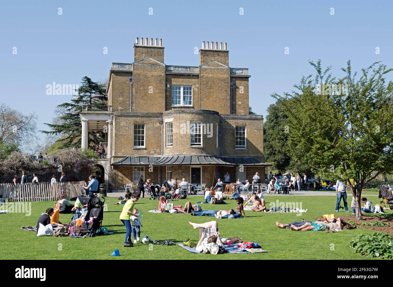 Les gens qui se trouvent sur l'herbe sous le soleil, à côté de la maison Clissode, parc Clissode Stoke Newington Banque D'Images
