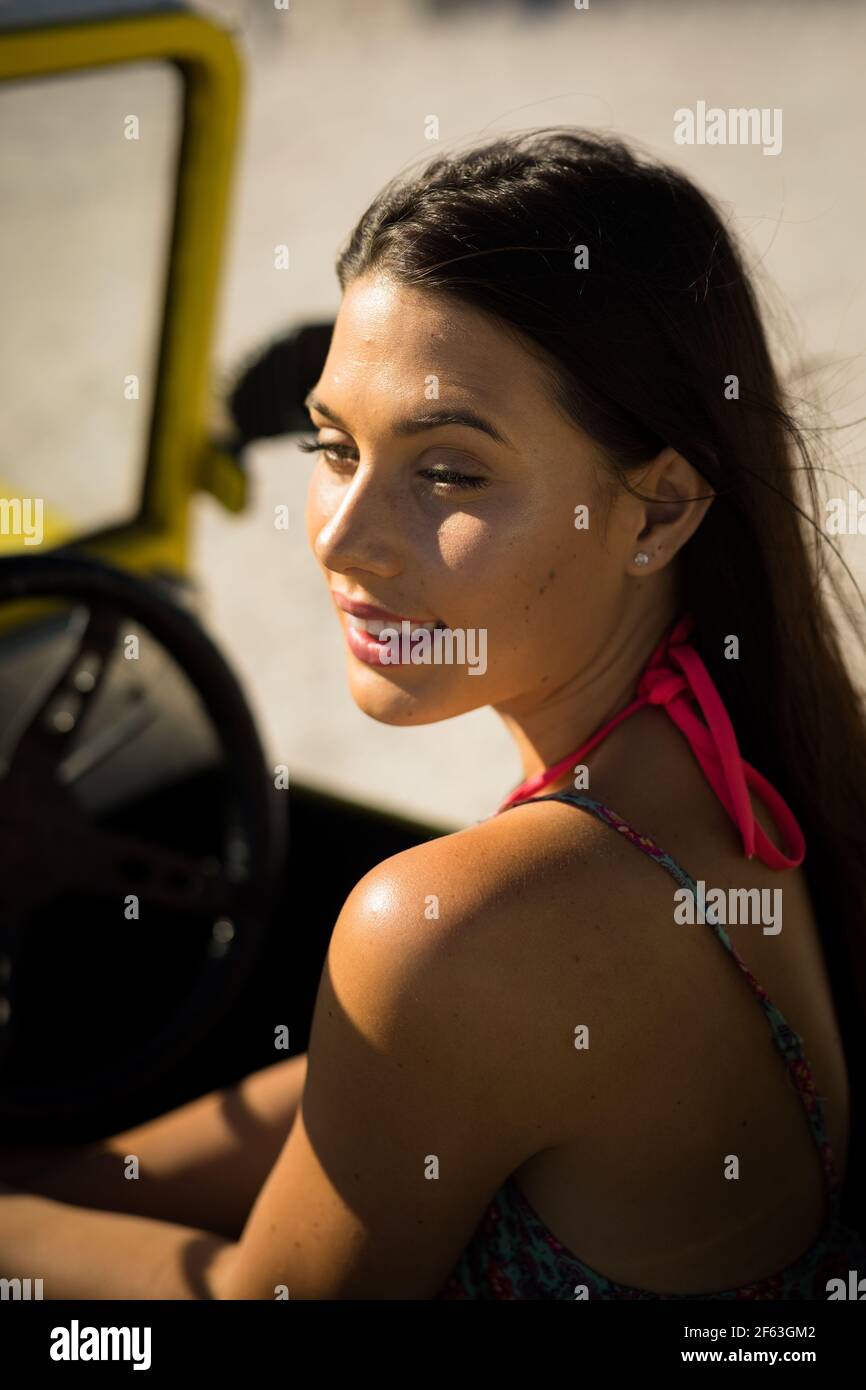 Bonne femme caucasienne assise dans un buggy de plage au bord de la mer Banque D'Images