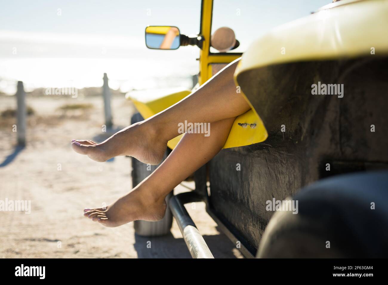 Partie basse de la femme caucasienne assise dans la plage buggy par la mer Banque D'Images