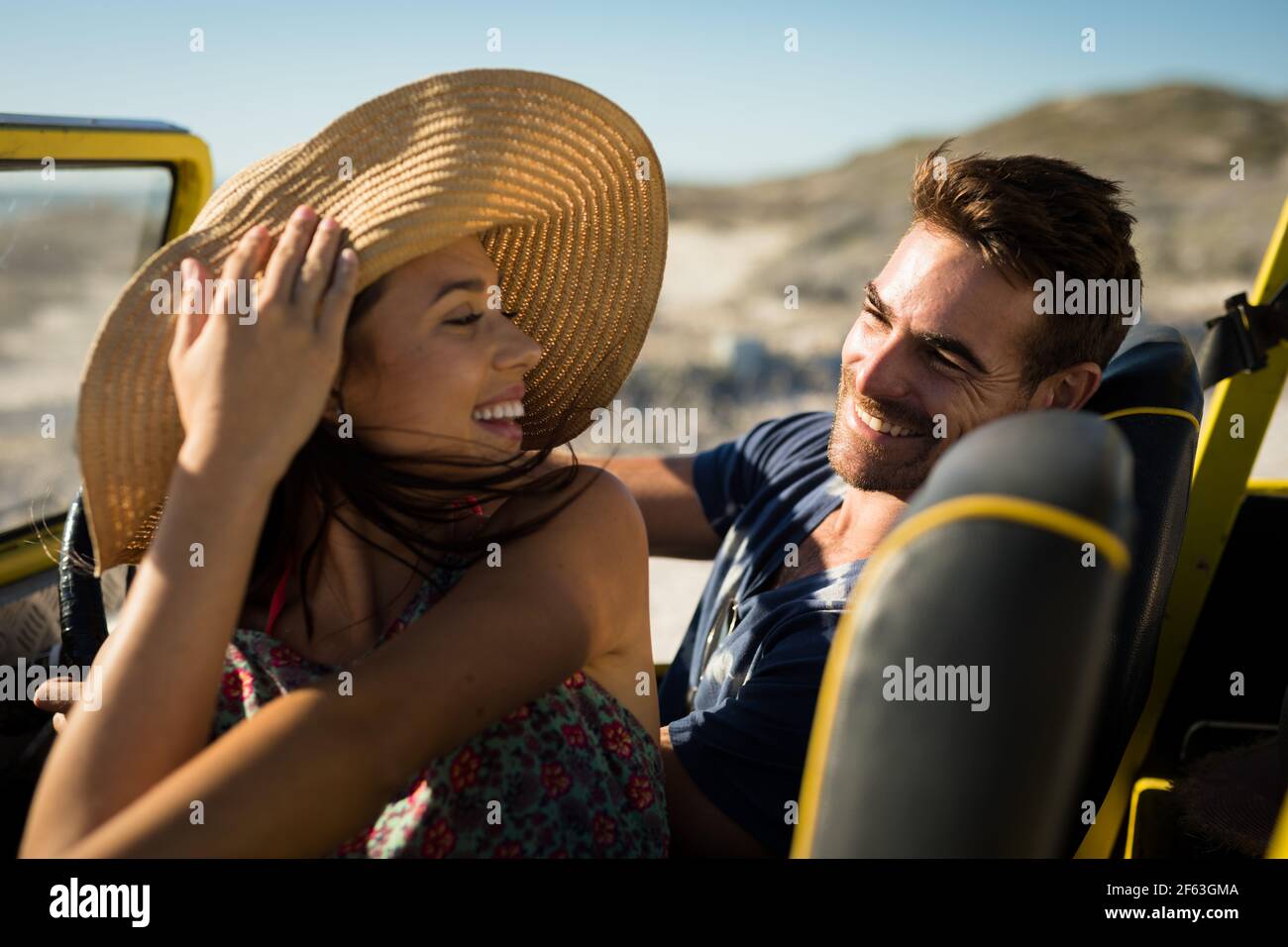 Heureux couple caucasien assis dans la plage buggy au bord de la mer sourire Banque D'Images